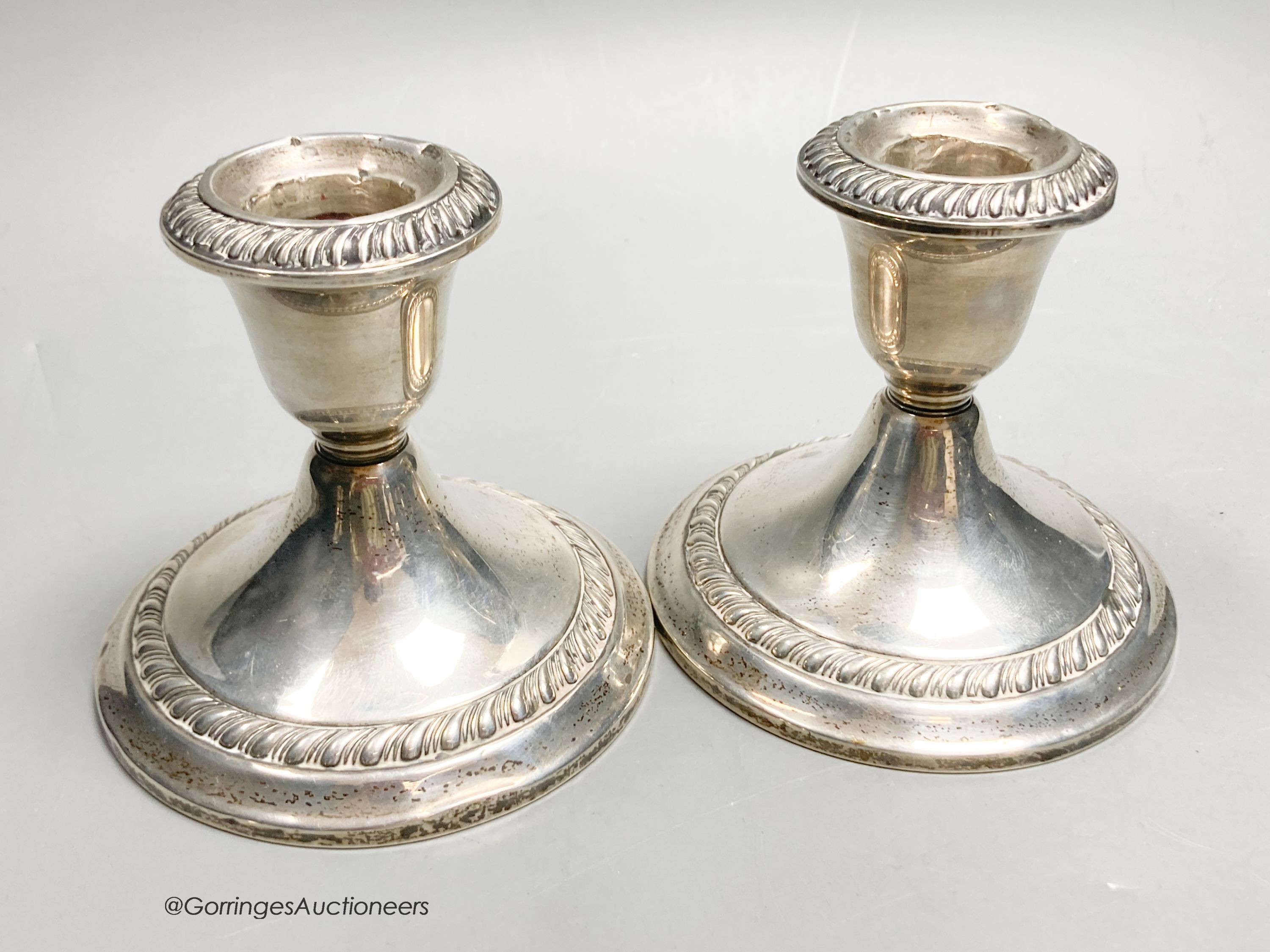 An American sterling three-branch candelabrum, 9.5oz and two pairs of similar dwarf candlesticks, 88mm, weighted.